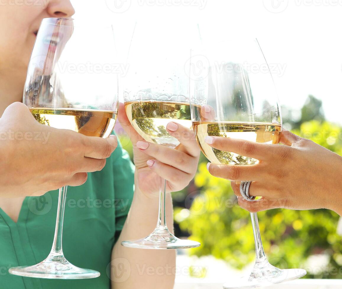 Crop friends clinking glasses of wine photo