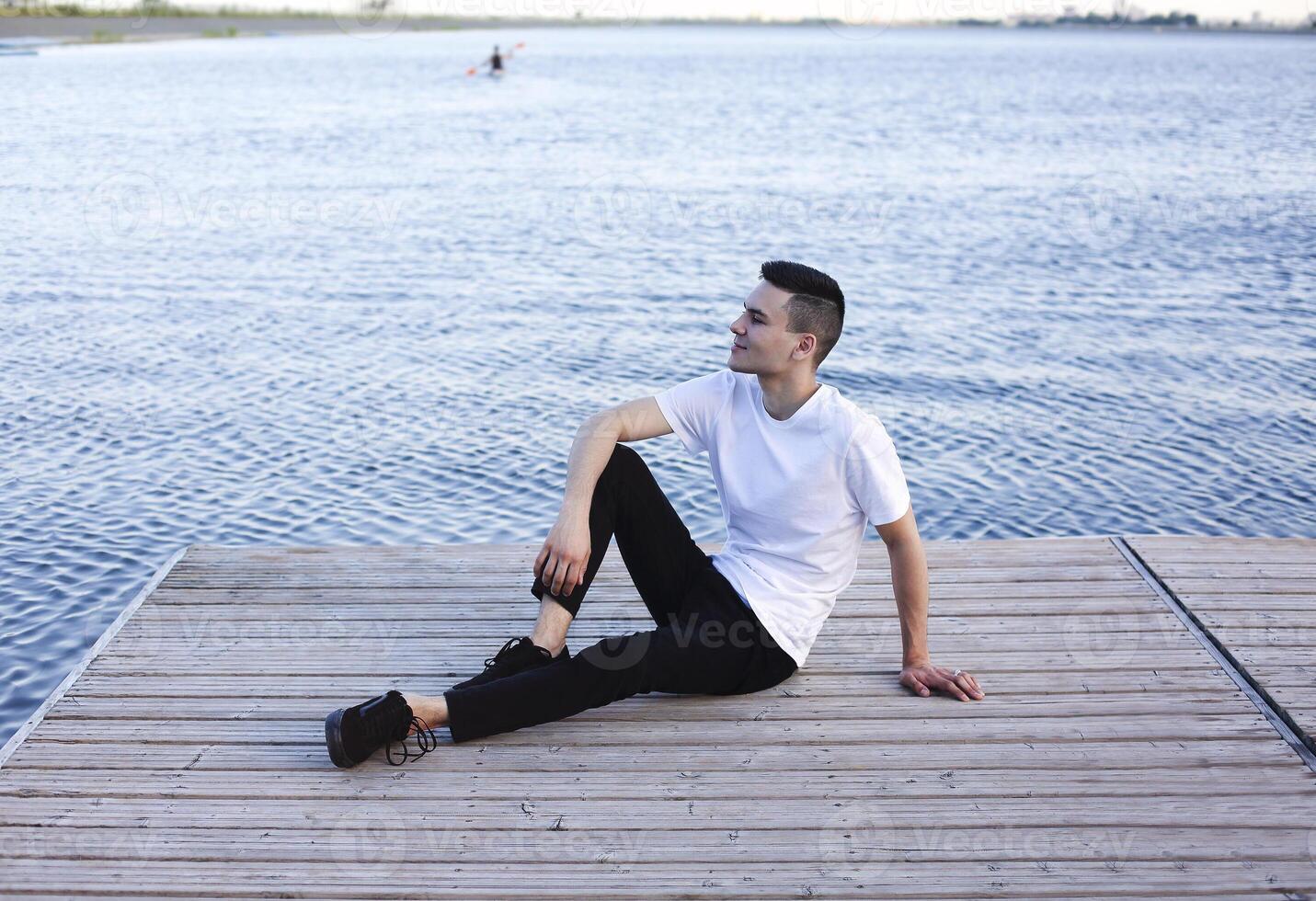 Calm man resting on wooden pier photo