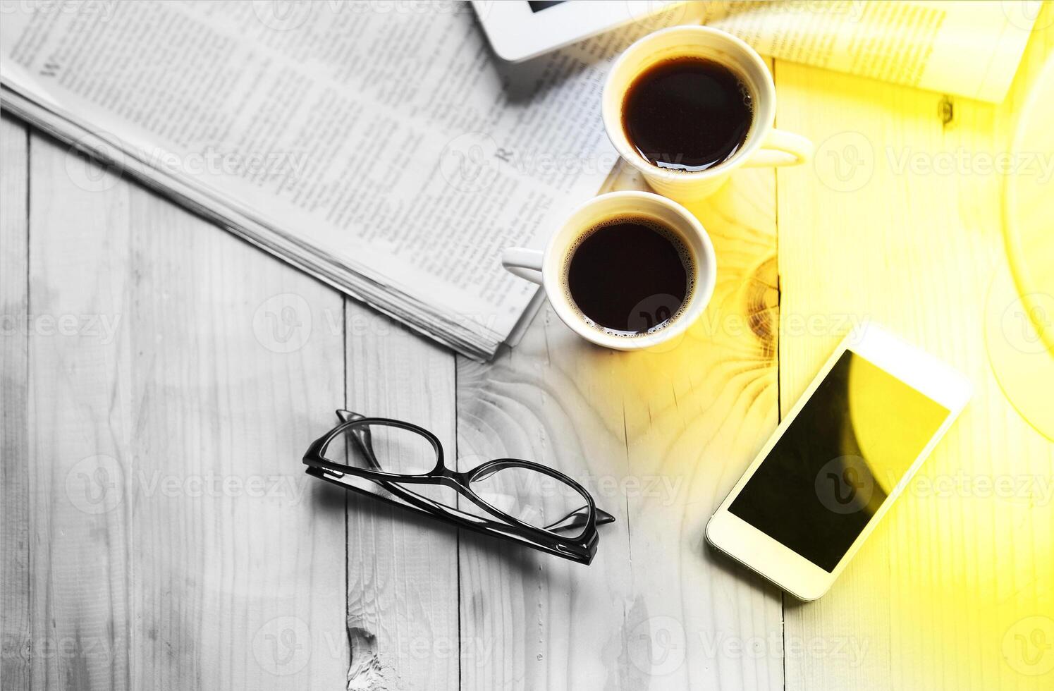 Black coffee with blank digital tablet and mobile phone, magazines and glasses on the table photo
