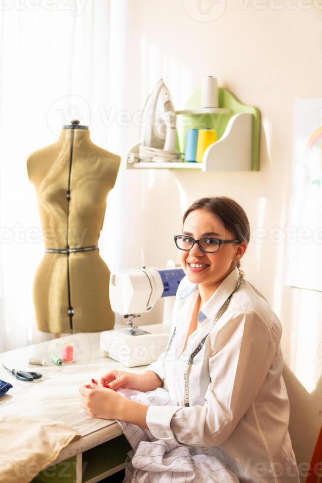 Female dressmaker creating clothes in workshop photo