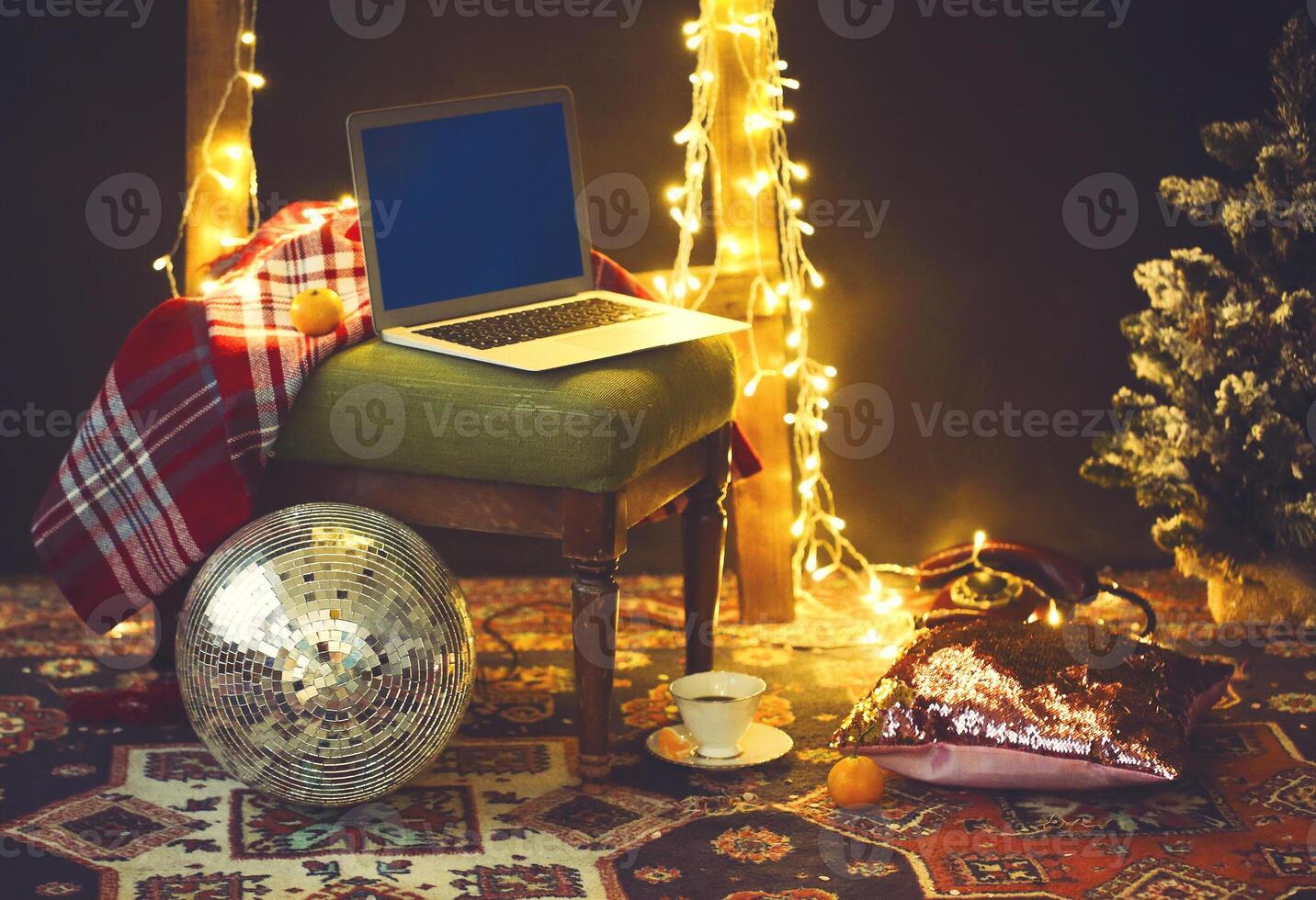 New Year's eve or Christmas still life with retro phone, disco ball, coffee, candle and blanket photo