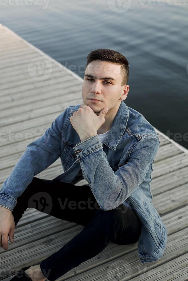 Calm man resting on wooden pier photo