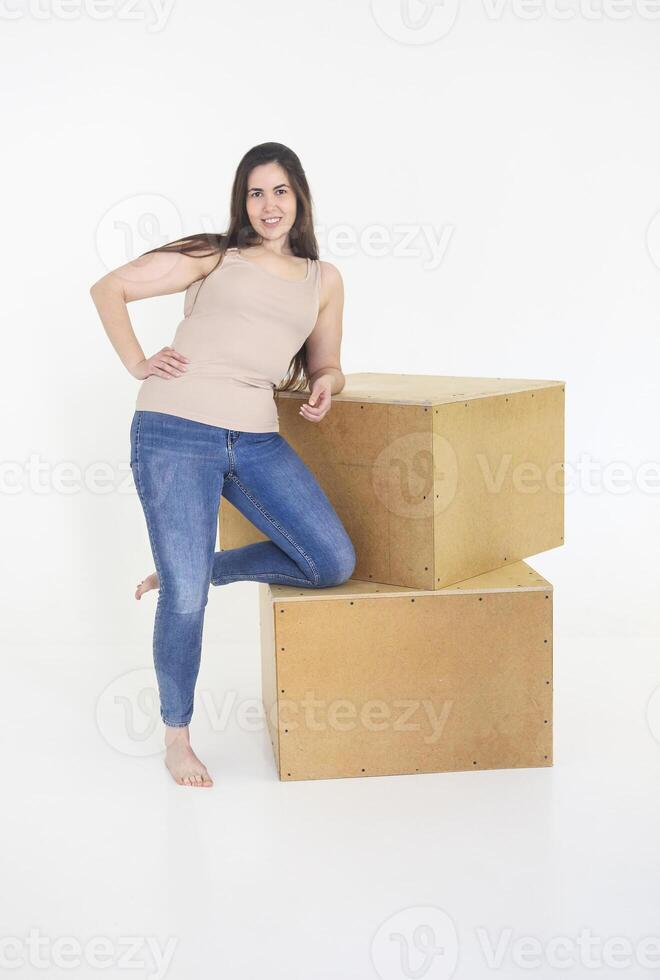 Beautiful plus size curly young brunette woman posing on white photo