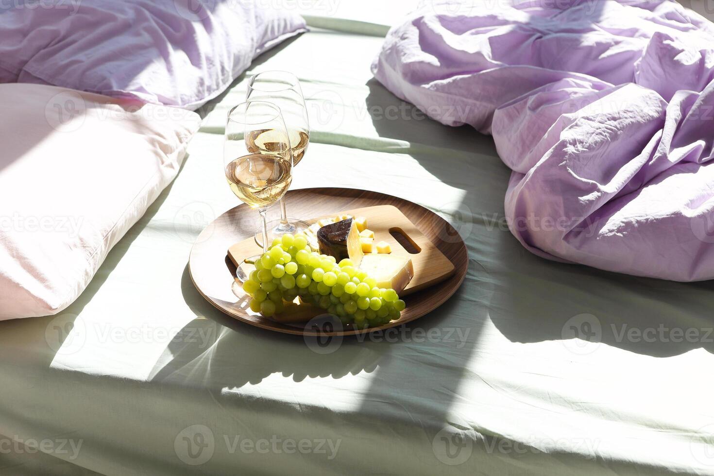 Wine and food on bed in sunny day photo