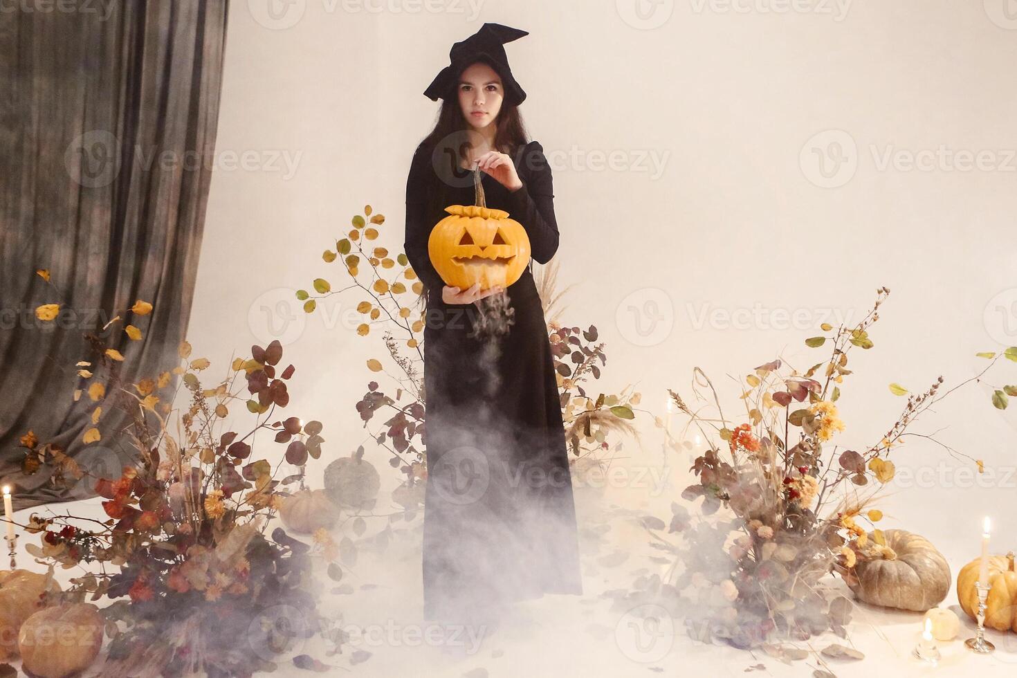 Woman in witch costume with pumpkin photo