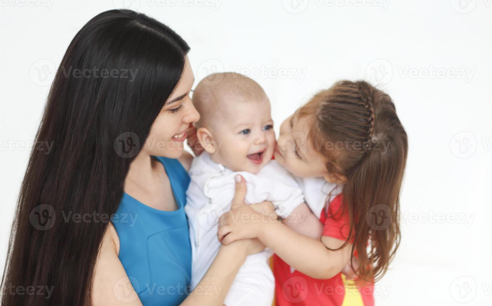 Happy mother and cute little kids spending time together and smiling at camera photo