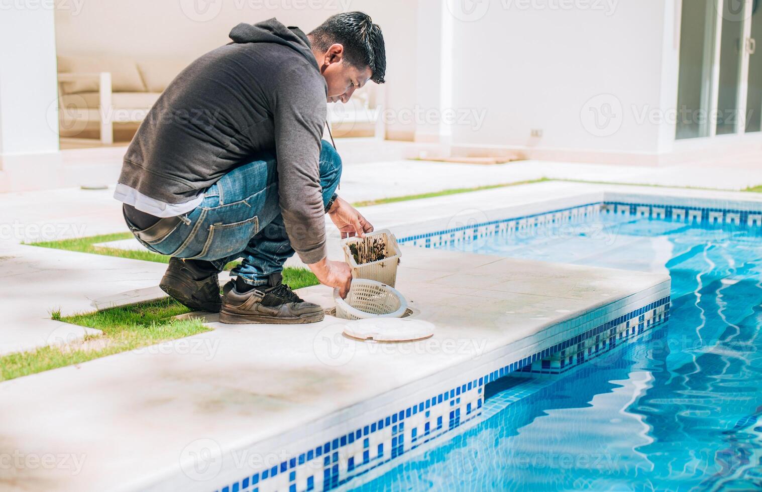 Man cleaning swimming pool filter basket. Person cleaning garbage filter basket for swimming pool photo