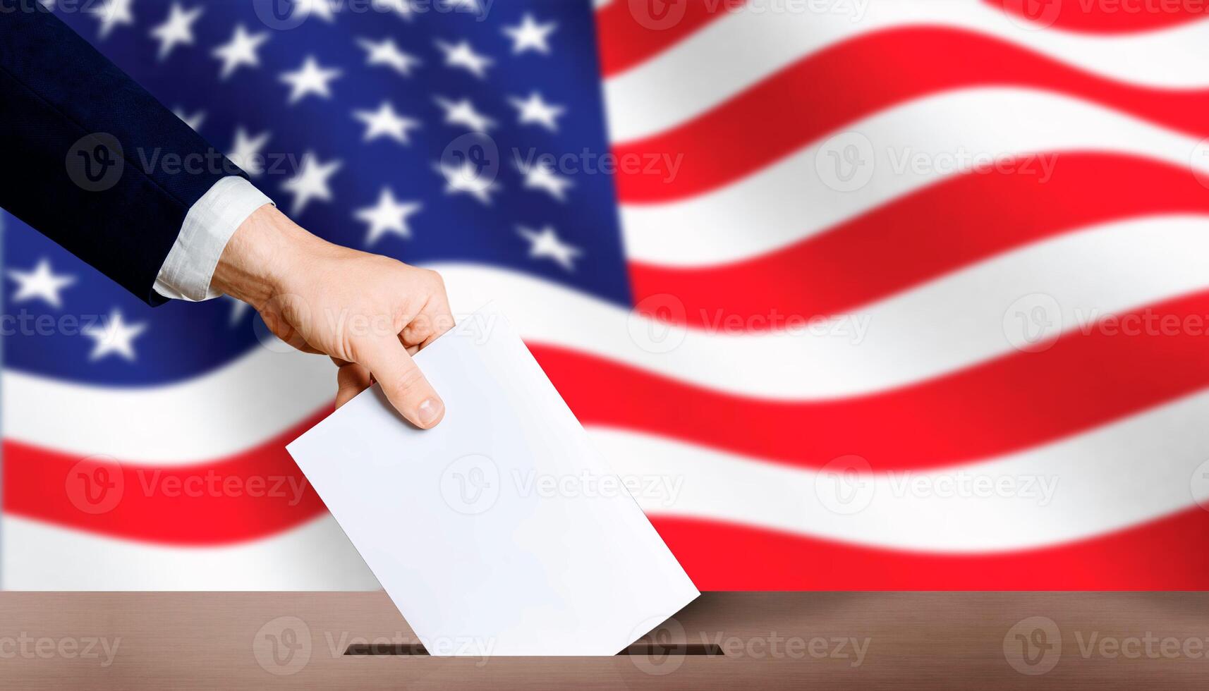 USA presidential elections. Hand holding ballot in voting ballot box with USA flag in background photo