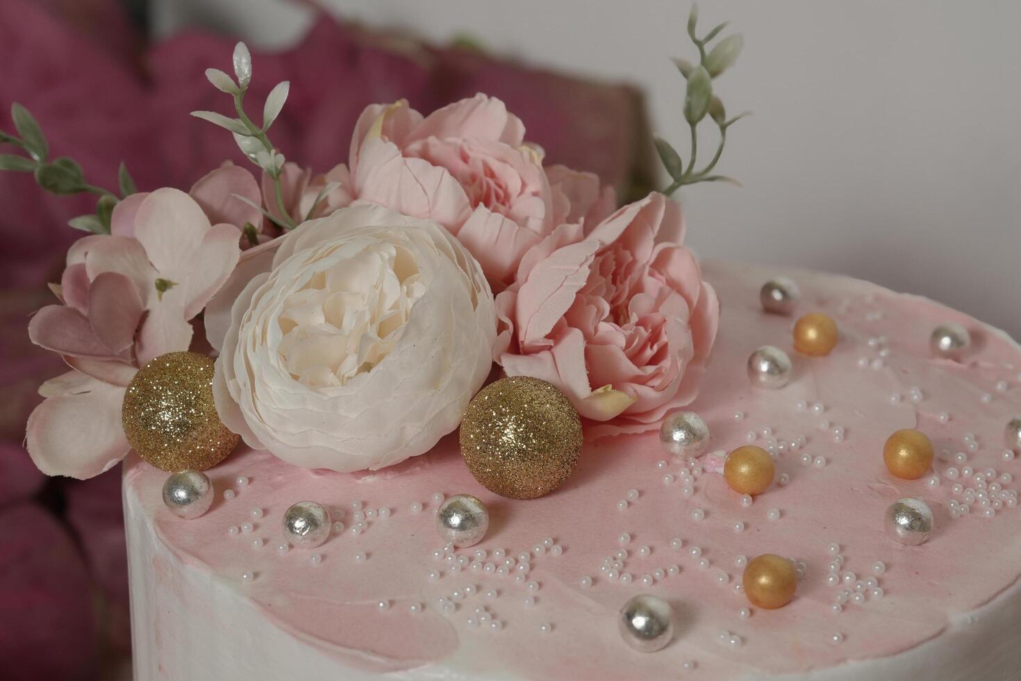 a pink cake with pearls and flowers on top photo