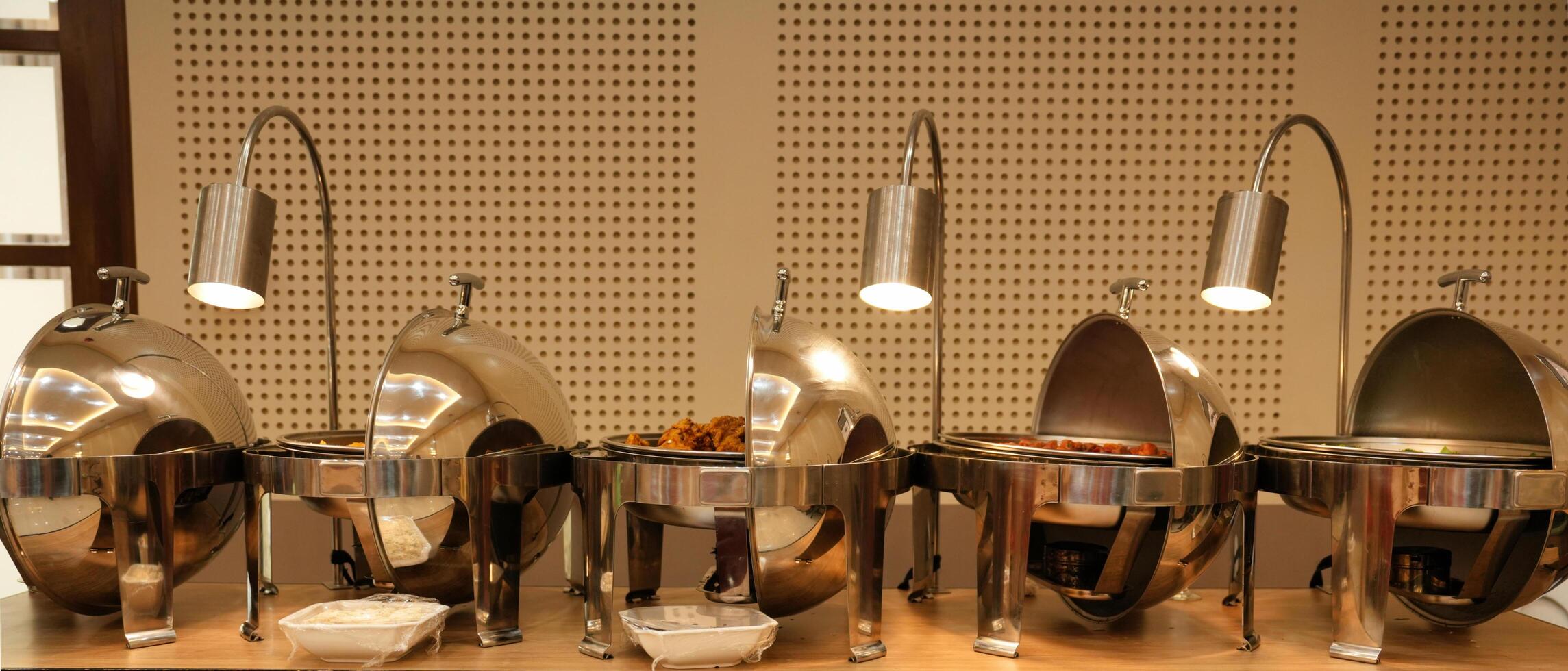 a buffet line with several silver trays and bowls photo