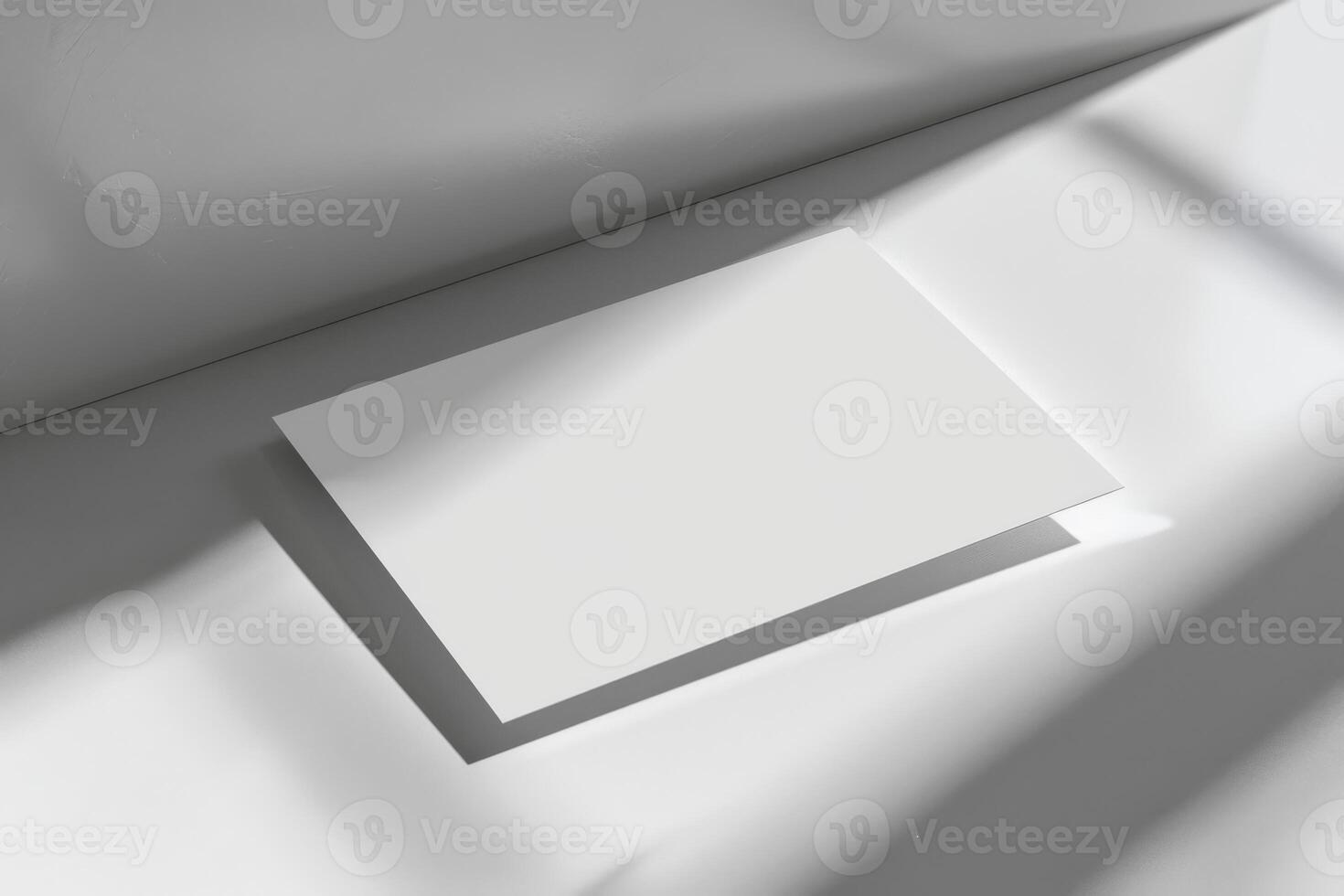 Top view of white business card with soft light and shadow on the wall for mockup photo
