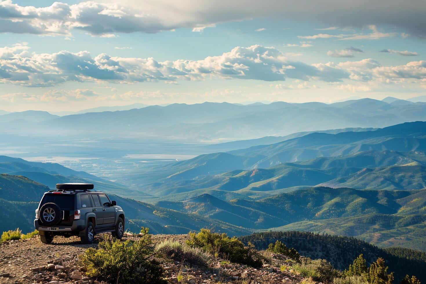 Powerful Full size SUV parked at rugged mountain overlook with panoramics of valleys and distant peaks photo