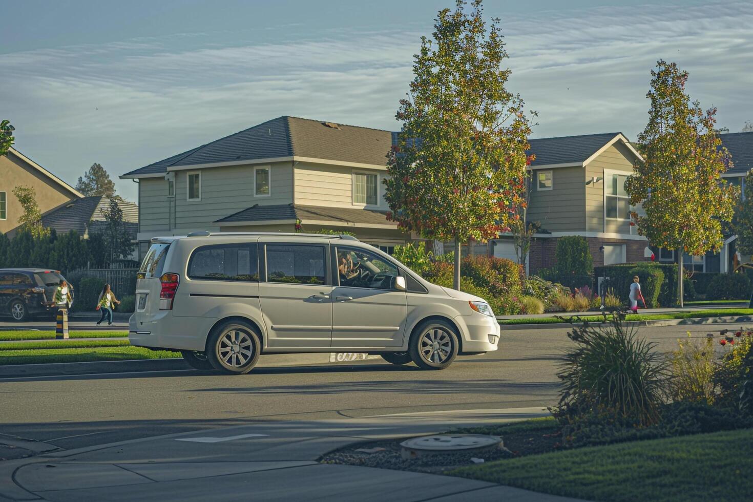 Safety Family minivan driving through residential neighborhood with speed bumps and children playing on sidewalks photo