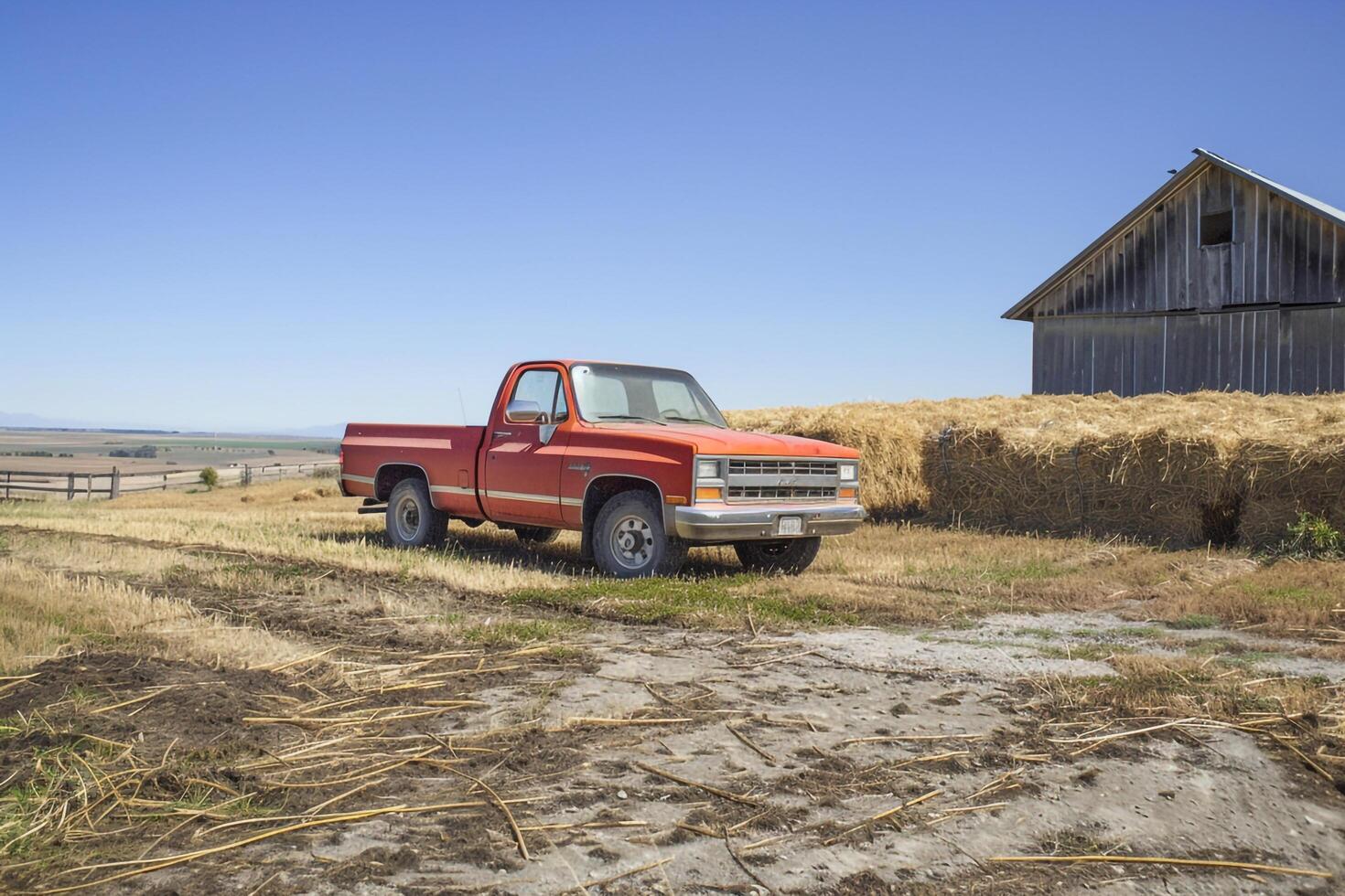 Strength Pickup truck parked on farm with haystacks and barn in the background under clear blue sky photo