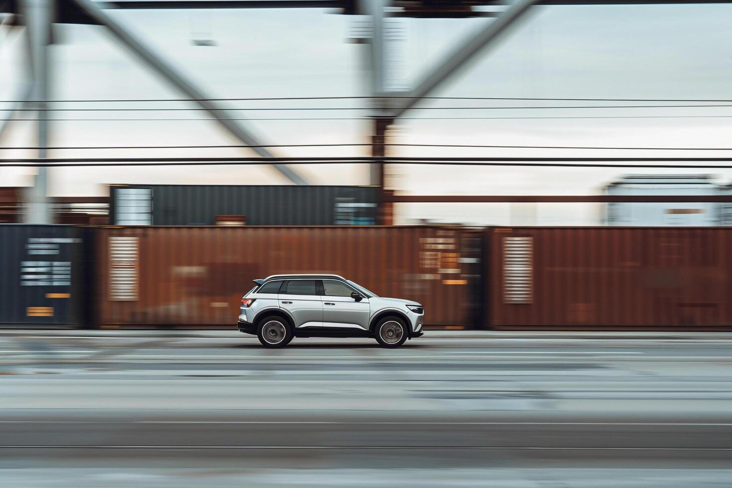 Urban Subcompact SUV driving through modern industrial district with warehouses and shipping containers lining the streets photo