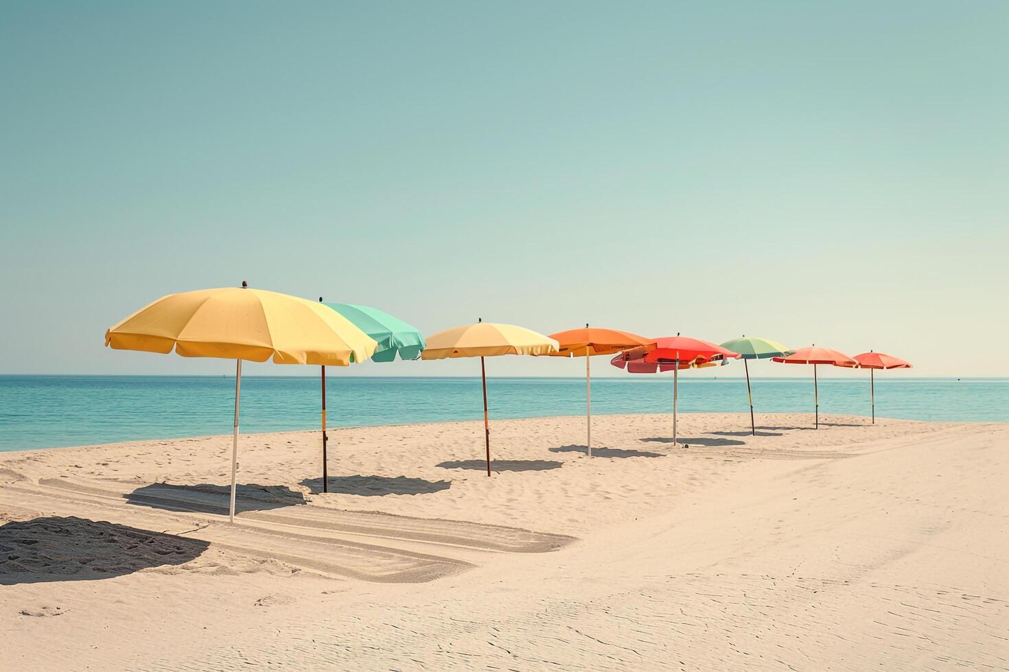Calmness at the beach with row of beach umbrellas casting colorful shadows on the sand photo