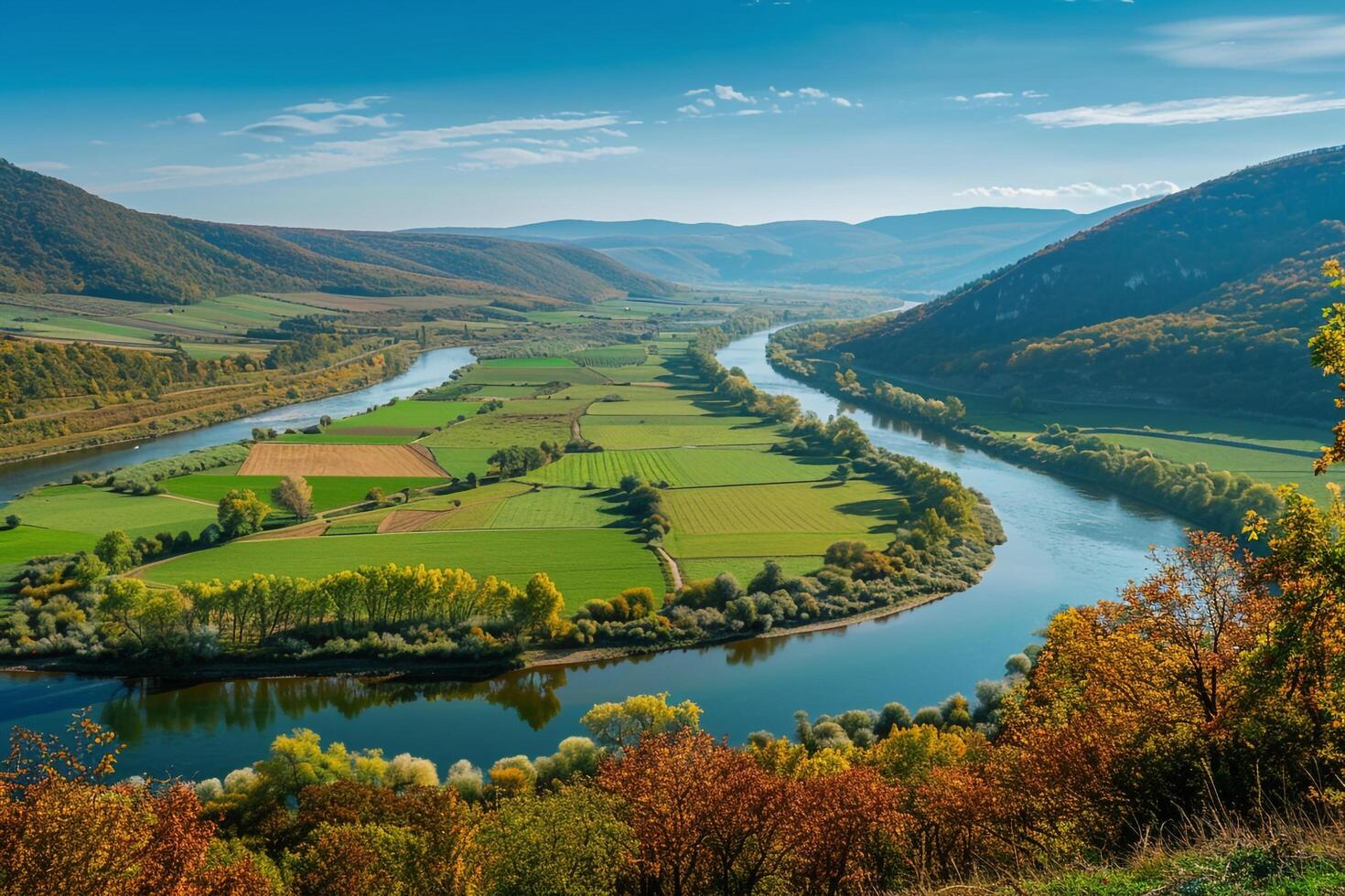 Colorful Autumn Foliage Surrounding Green Valley with Meandering River Clear Blue Sky Background Nature photo
