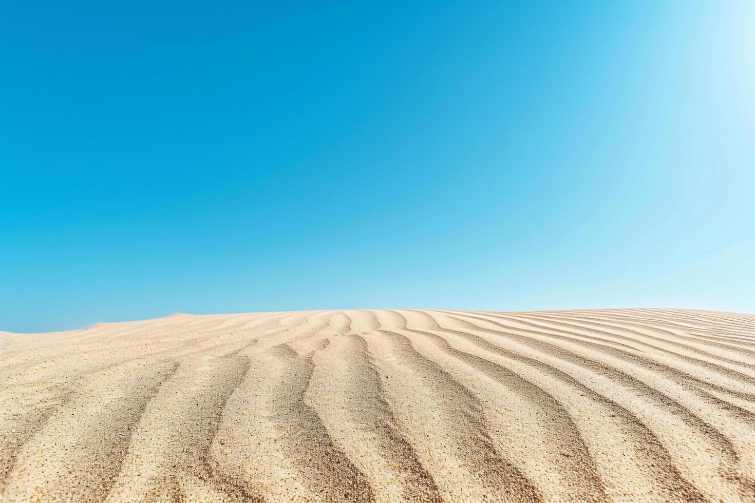 Smooth rippled sand patterns under clear blue sky at midday background nature photo