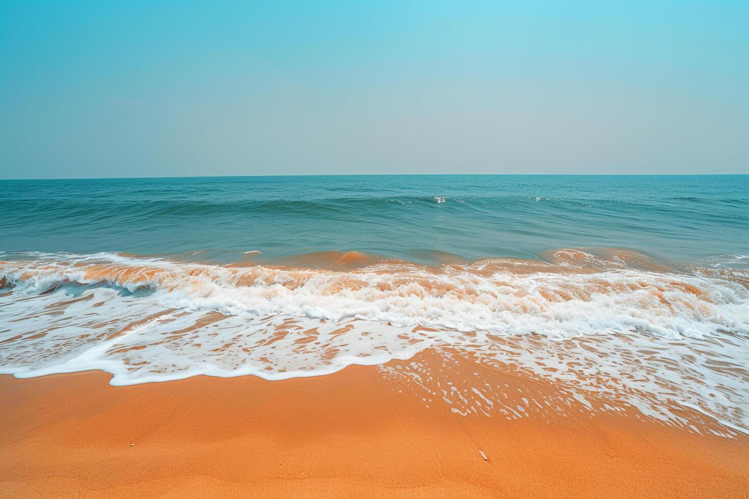 Empty Stretch of Golden Sand with Gentle Waves Lapping at the Shore Under a Clear Blue Sky Background Nature photo
