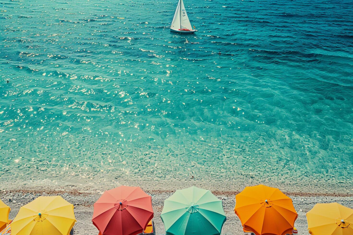 beach umbrellas lining the shore with clear turquoise waters and a distant sailboat on the horizon nature background photo