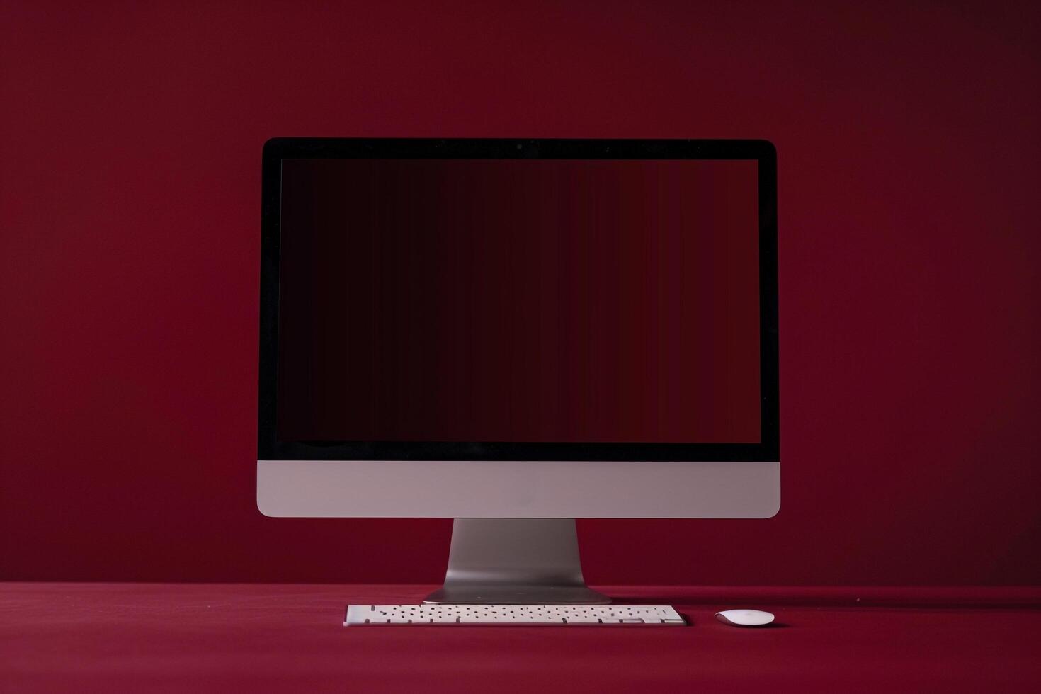 Computer monitor mockup on rich burgundy background with blank screen photo