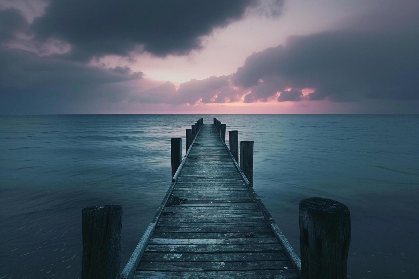 Wooden Pier Stretching into Ocean Under Calm Twilight Sky Background photo