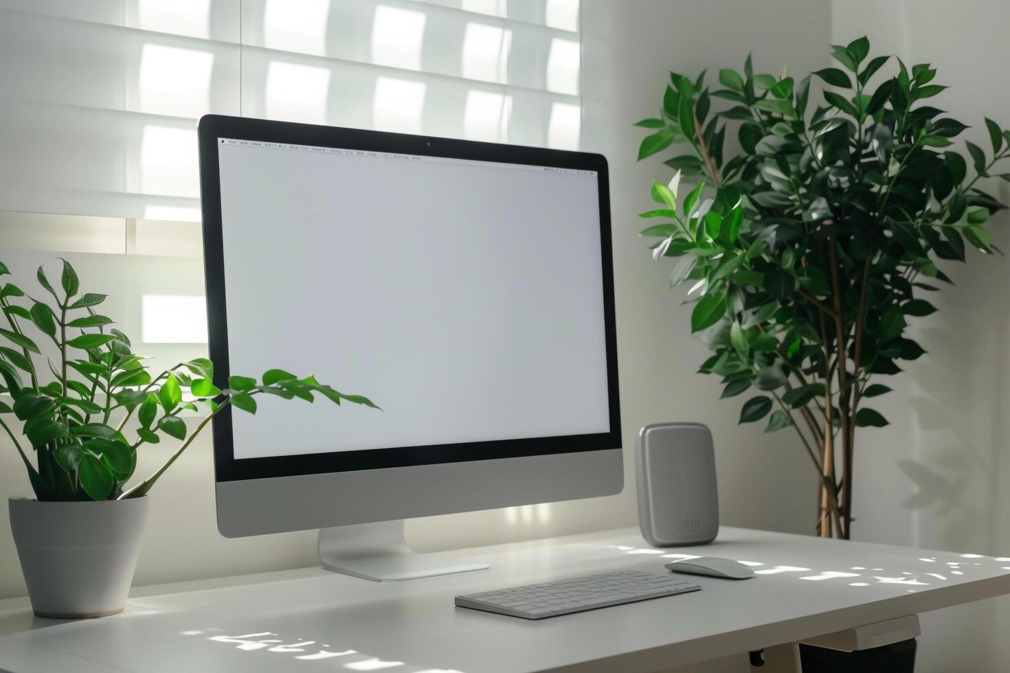 Computer mockup on a white desk with a plant in a space photo