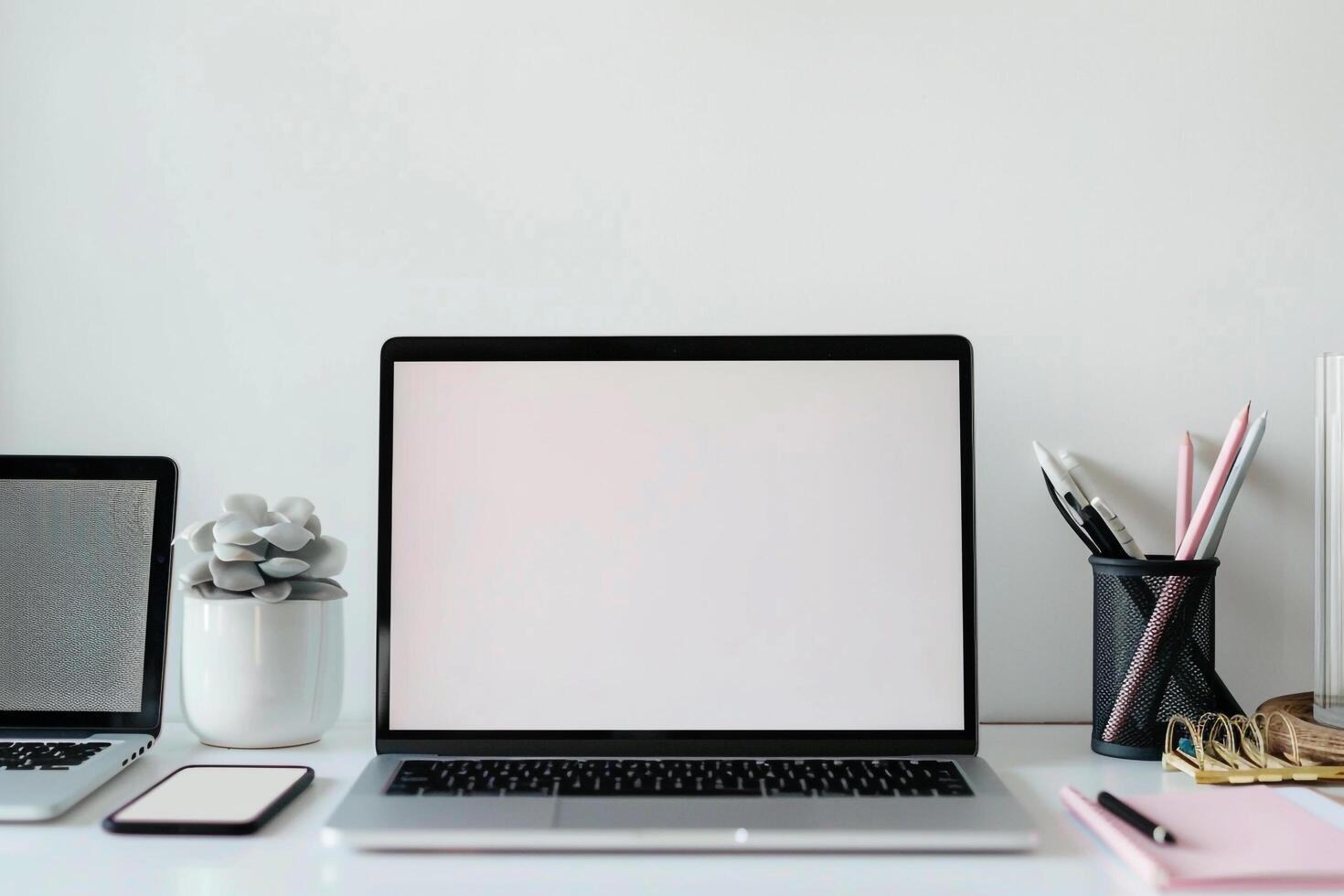 Laptop Mockup Background on white desk with pens and notepad for efficiency photo