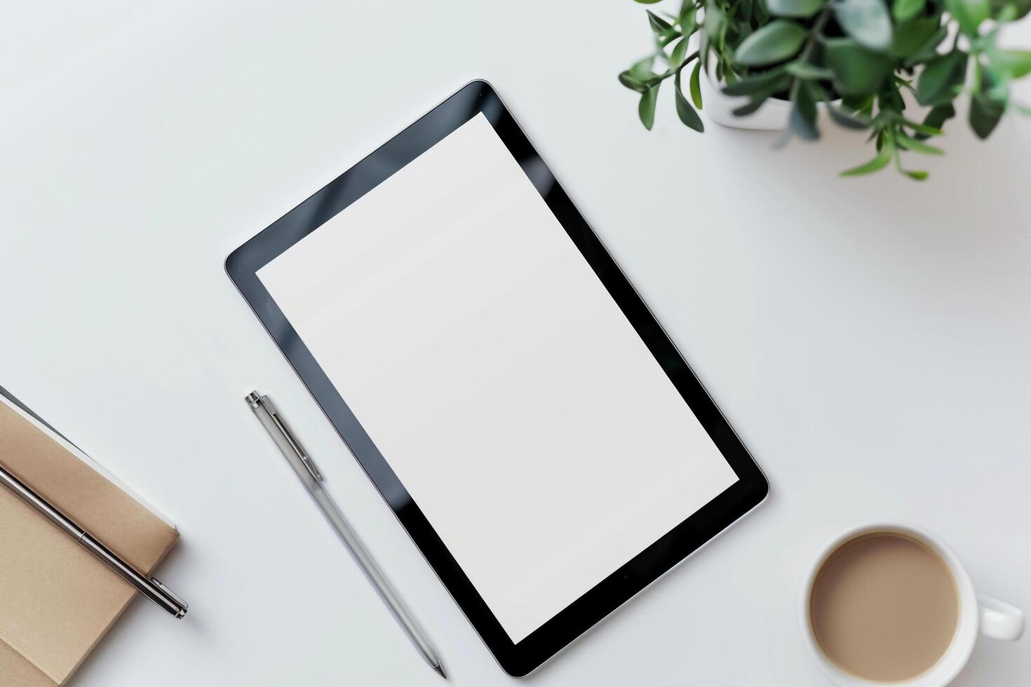 Tablet Positioned on White Desk with Green Plant and Office Accessories photo