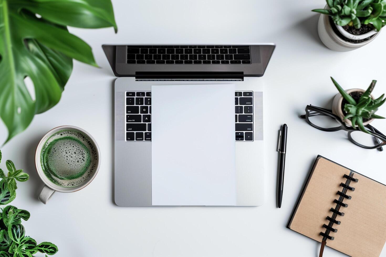 Laptop Mockup with Open Notebook on White Desk with Writing Materials photo