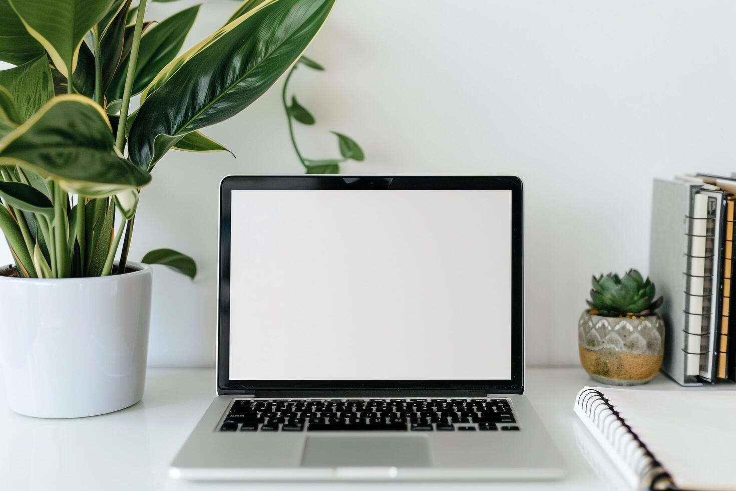 Laptop Mockup on White Desk with Open Notebook and  Writing Materials photo