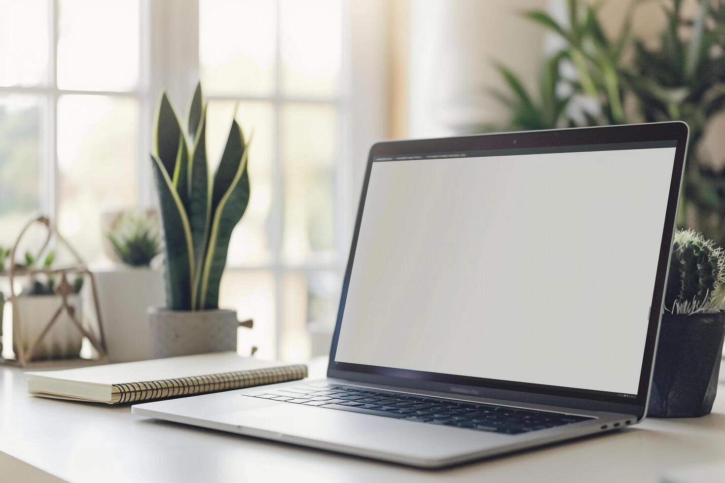 Laptop Mockup on White Desk with Open Notebook and Writing Materials photo