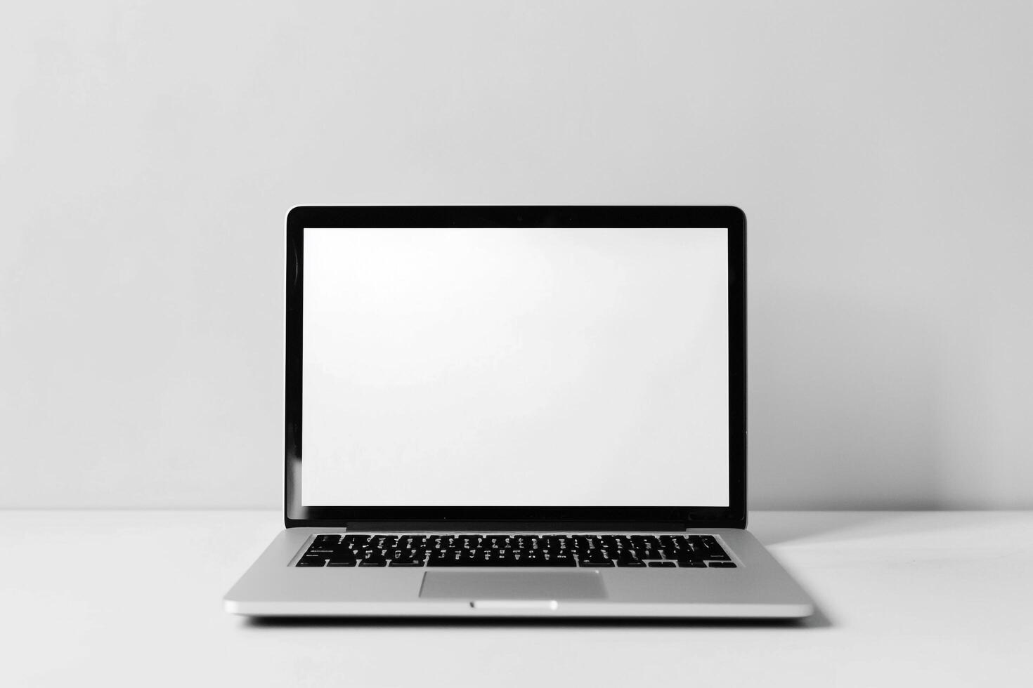 Laptop Mockup with Blank Notebook Open on White Desk photo