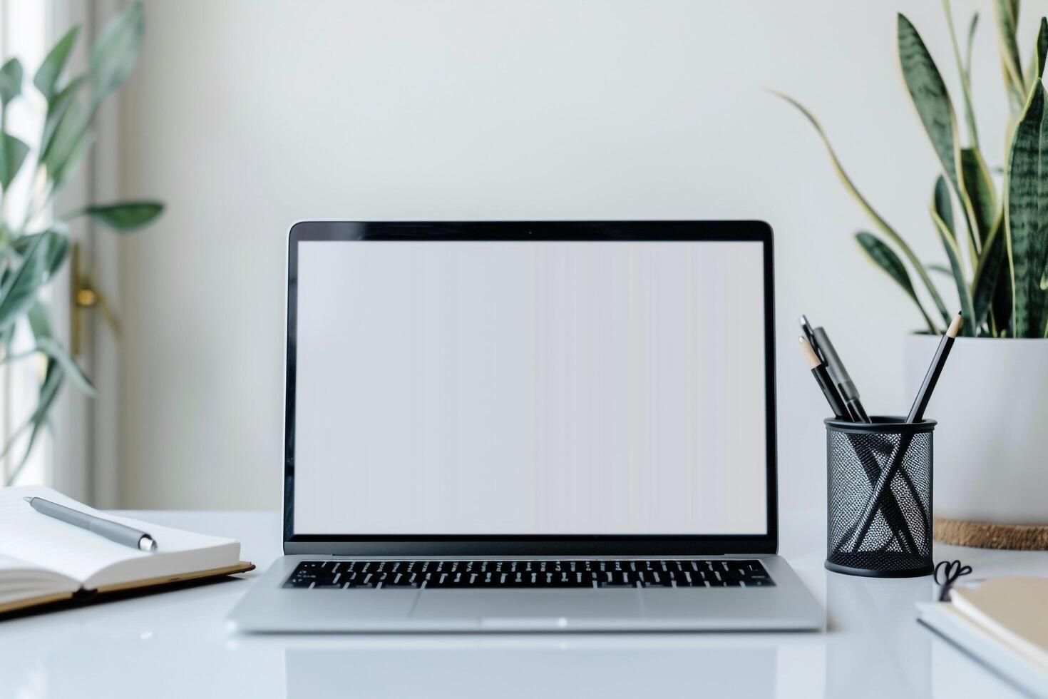 Laptop Mockup Background on a White Desk with Open Notebook and   Writing Setup photo