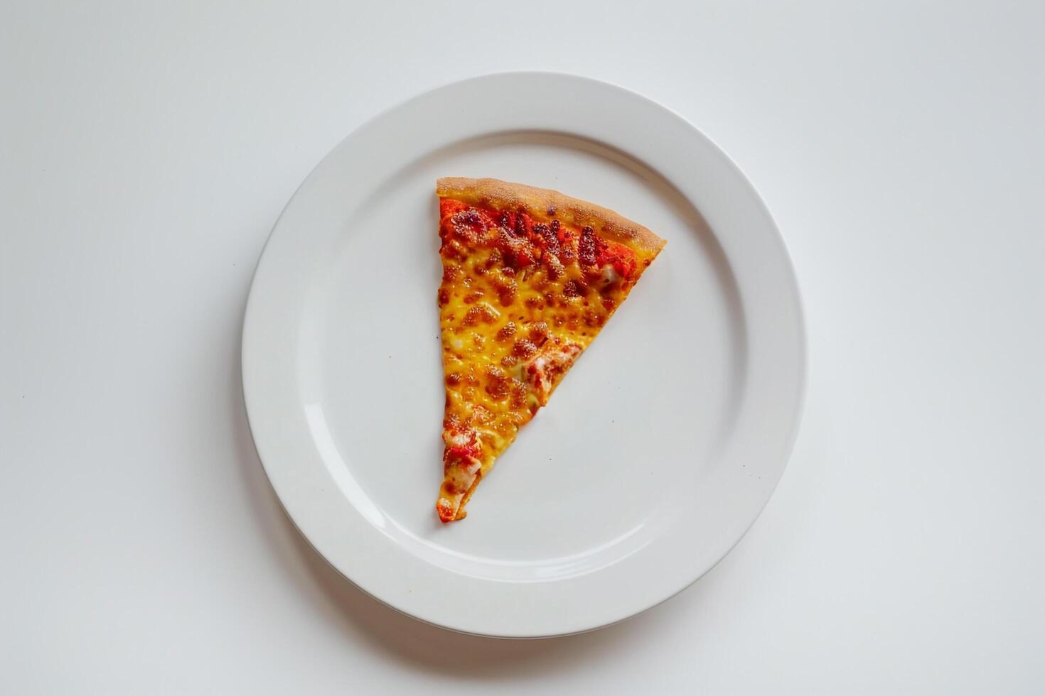 Desktop setup with a single slice of pizza on a white plate photo