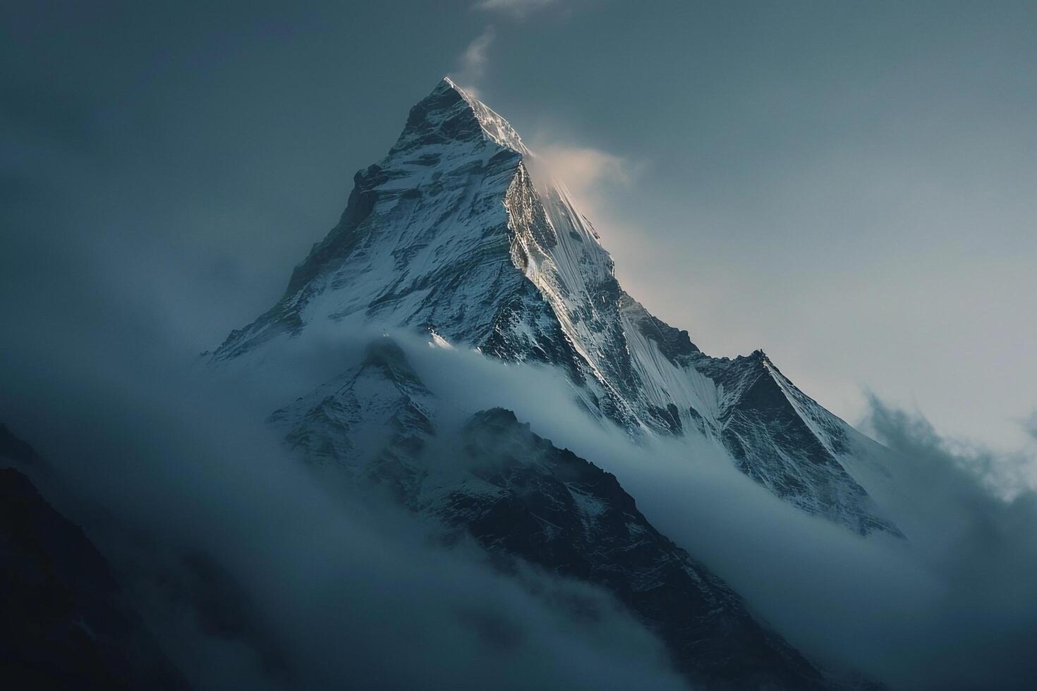Snow Capped Mountain Peak at Dawn with Mist Swirling Around in a Majestic Winter photo