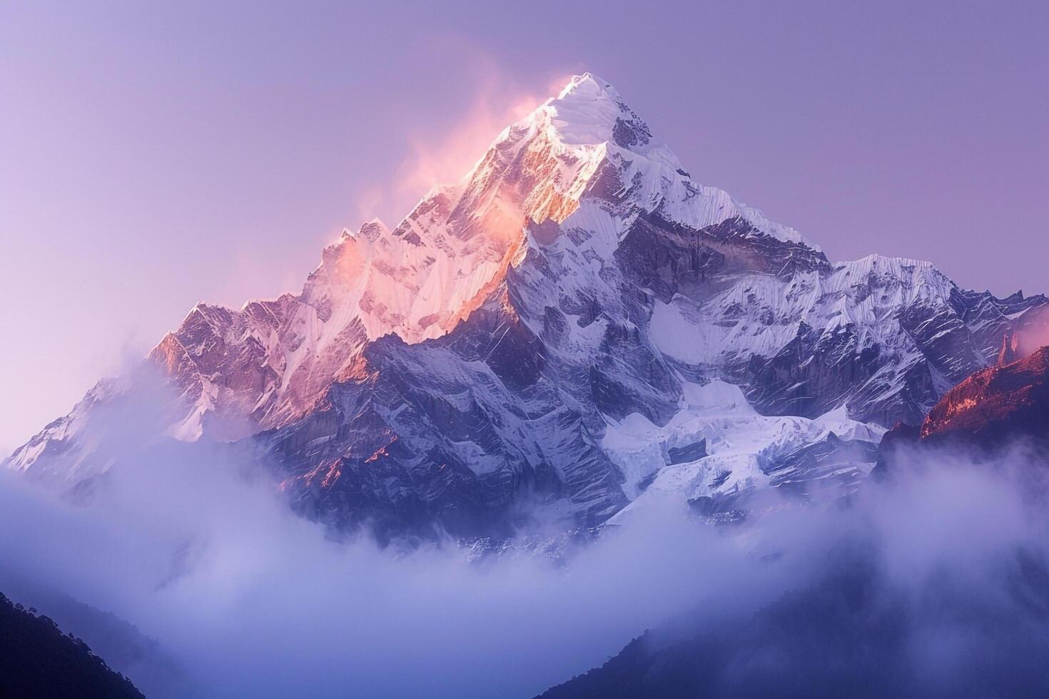 Snow Capped Mountain Peak at Dawn with Mist Swirling Around in a Beautiful Winter Wonderland photo
