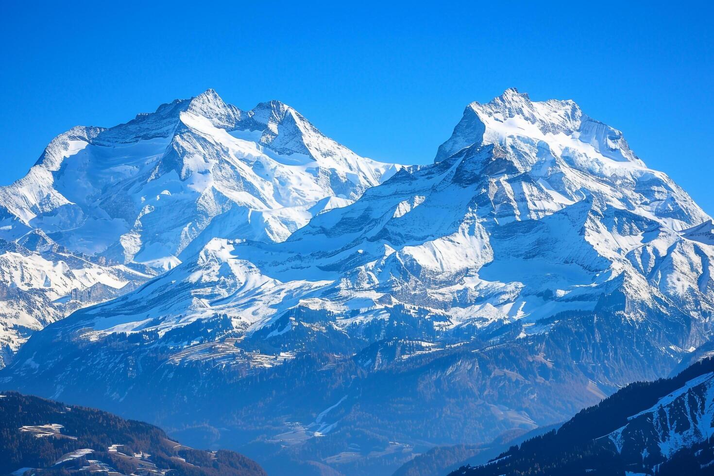 Snow Capped Peaks of the Swiss Alps Under a Crisp and   Blue Sky photo
