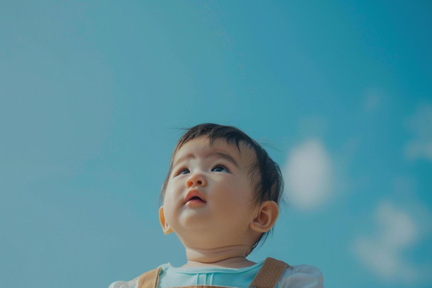Baby Surrounded by a   Sky Radiating Happiness and Enjoying the Outdoors photo