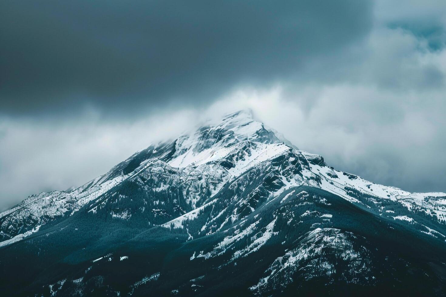 Snow Capped Mountain Peak at Dawn with Mist Swirling Around in a Majestic Winter photo