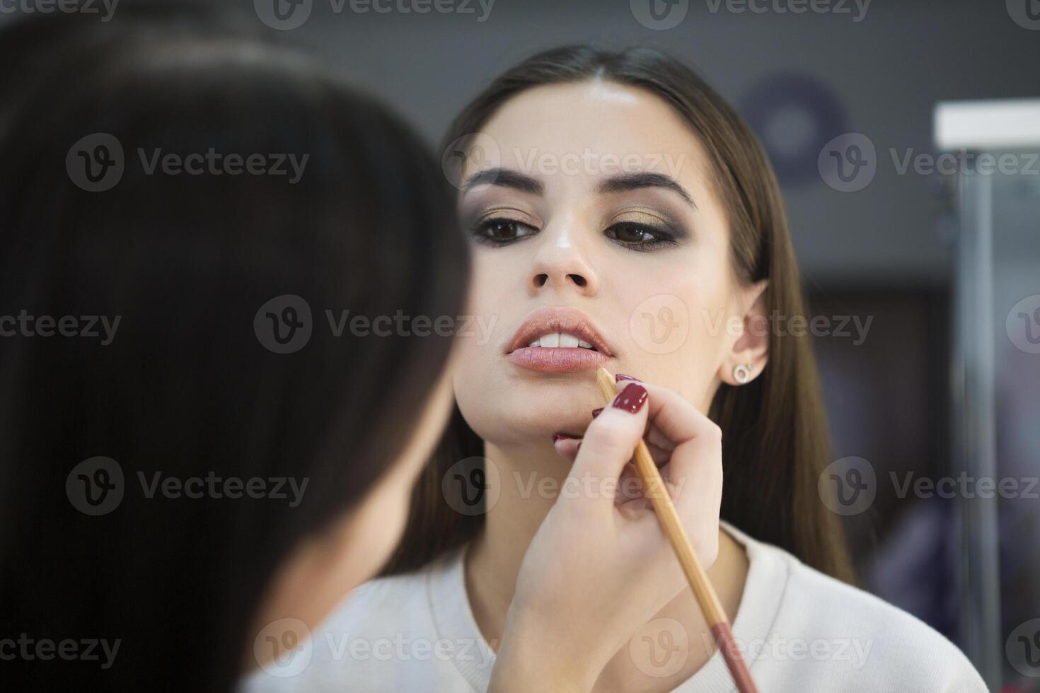 Professional make up artist doing make up in beauty salon photo