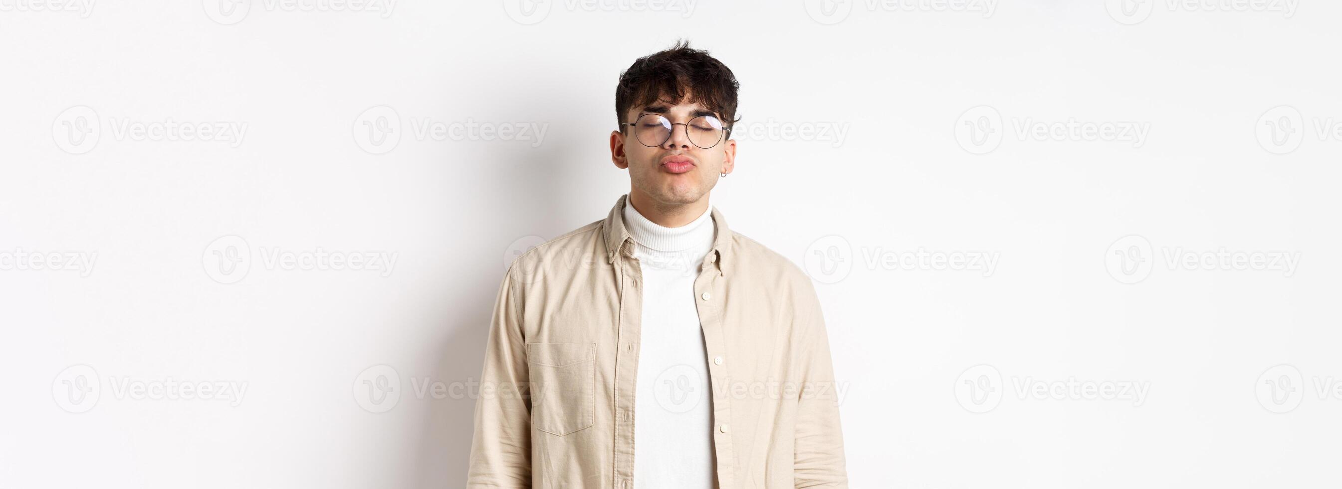 Cute boyfriend in glasses waiting for kiss, having romantic date on Valetines day, white background. Concept of relationship and romance photo
