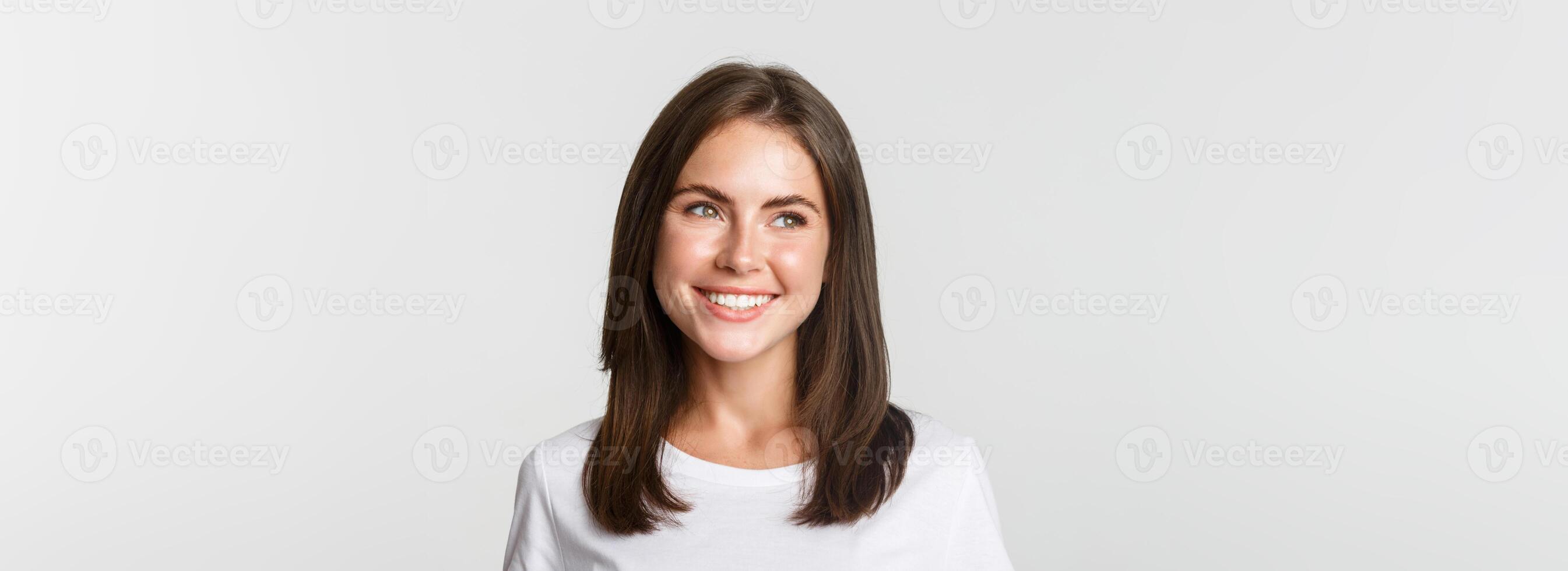 Portrait of attractive thoughtful girl smiling and looking left, white background photo
