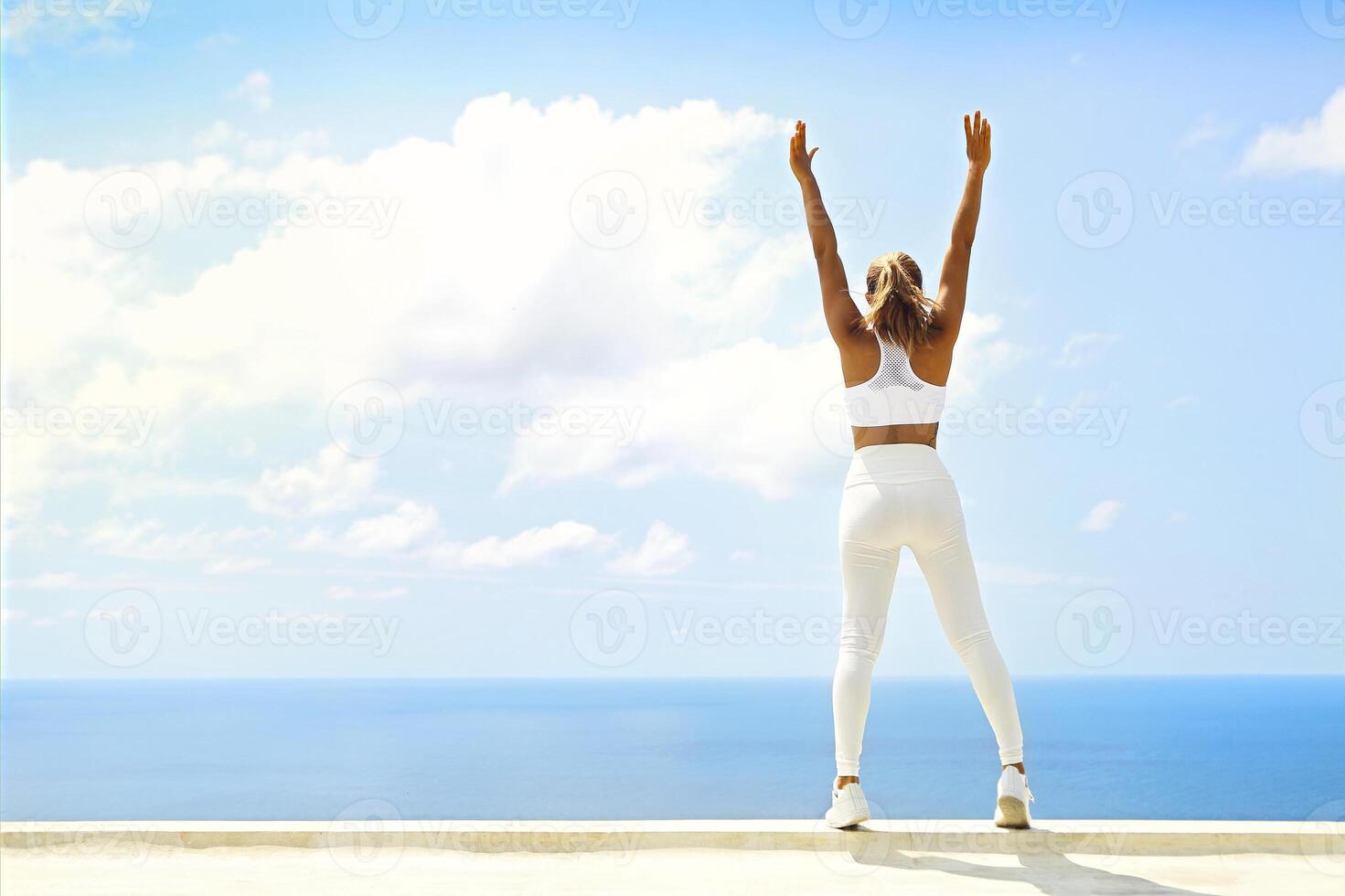 Beautiful woman making stretching exercises in the beach photo