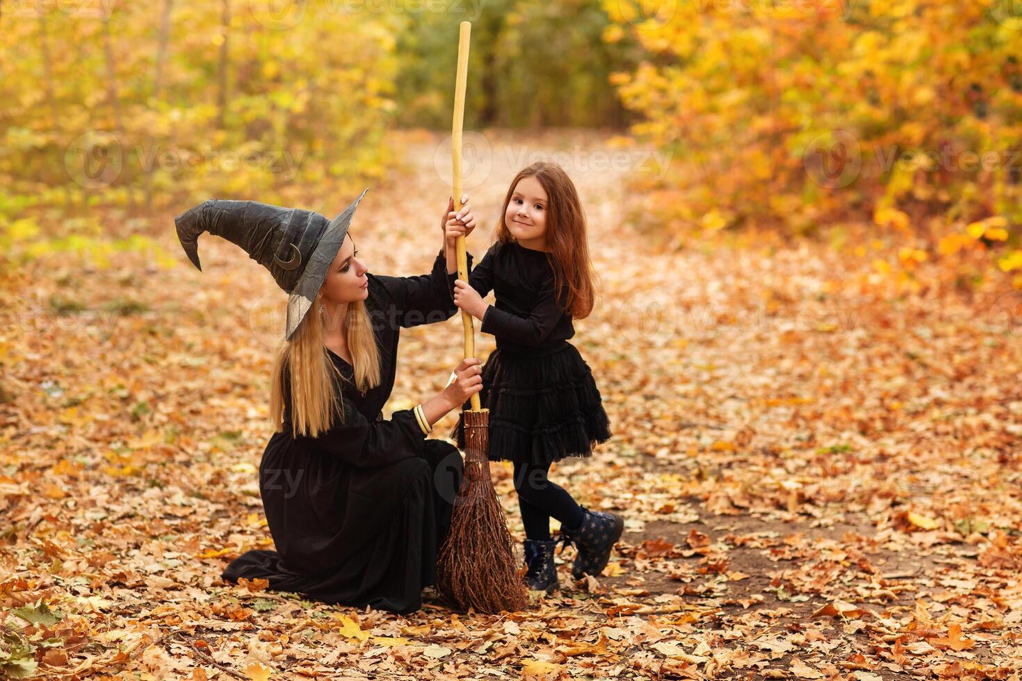 Mother and daughter sweeping path on Halloween day photo