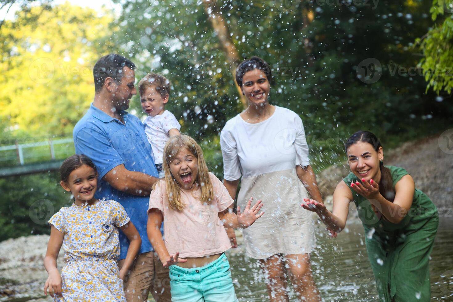 Adults and kids having fun in mountain river photo