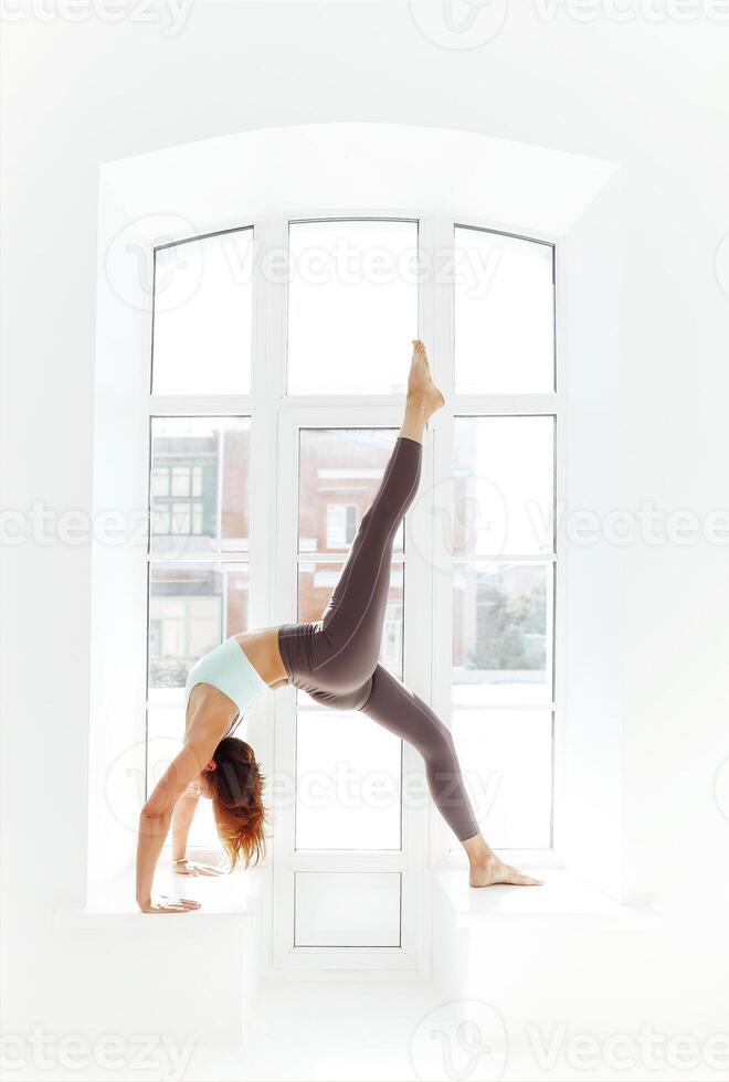 Flexible woman doing yoga at home photo