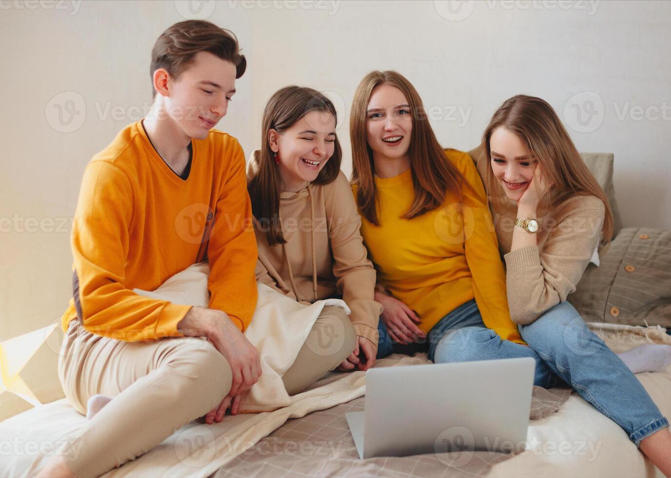 Teenage friends watching funny content on laptop and laughing photo