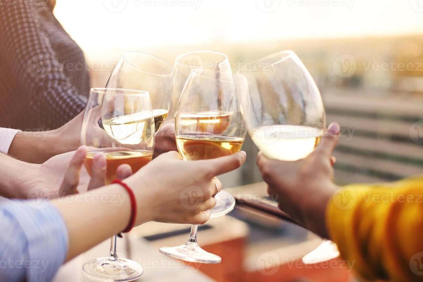Crop friends clinking glasses of wine photo