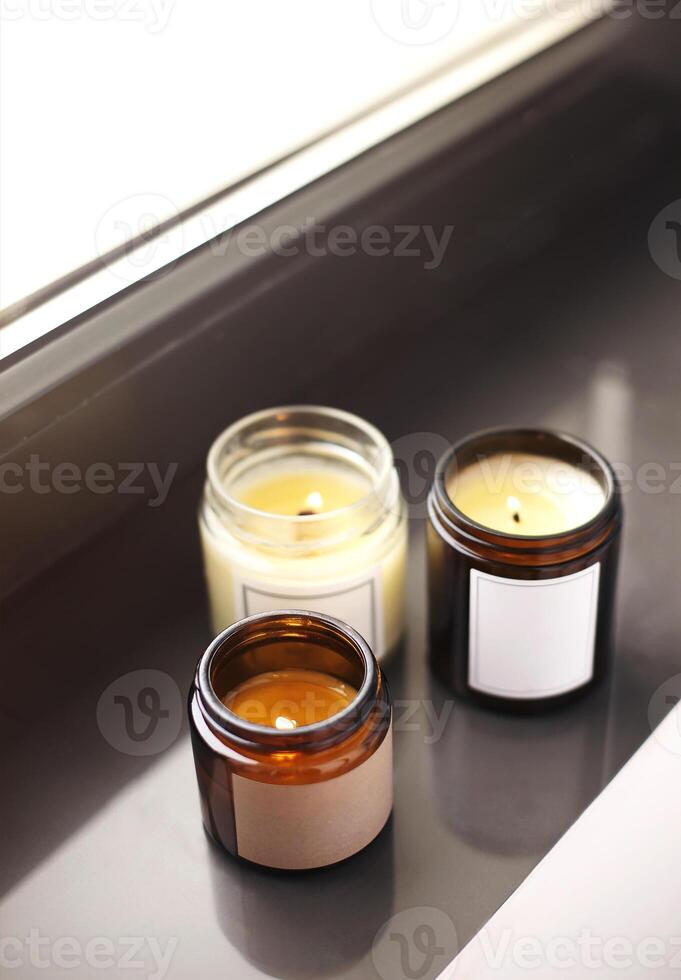 Lighting candles on windowsill in home interriors close up photo